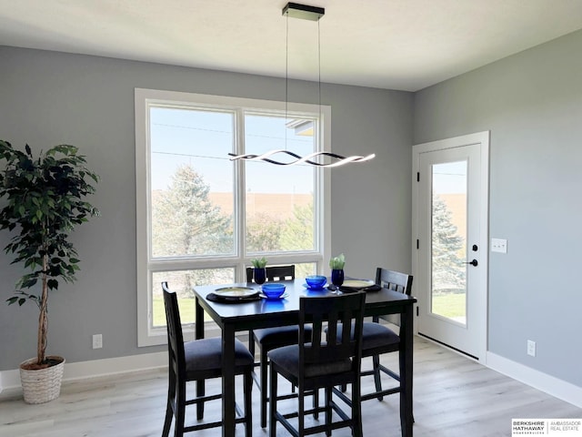 dining area with a wealth of natural light and light hardwood / wood-style floors