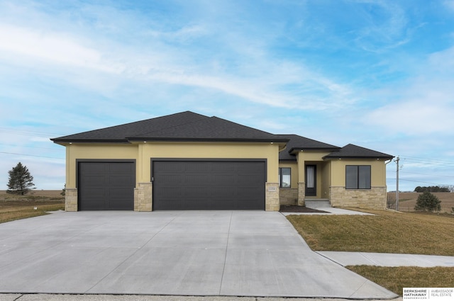 prairie-style home with a garage and a front yard