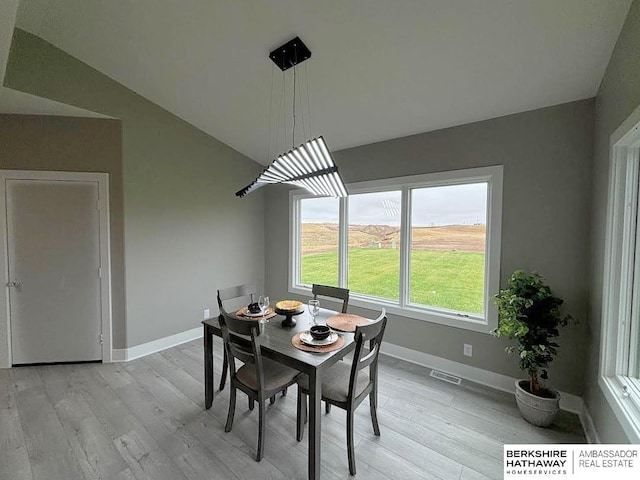 dining area featuring lofted ceiling and light hardwood / wood-style floors