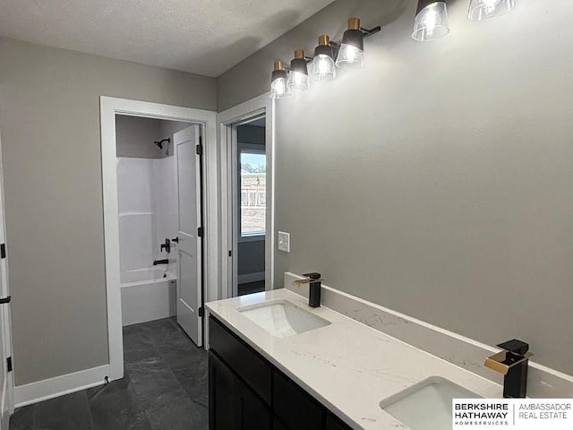 bathroom with vanity, bathtub / shower combination, and a textured ceiling