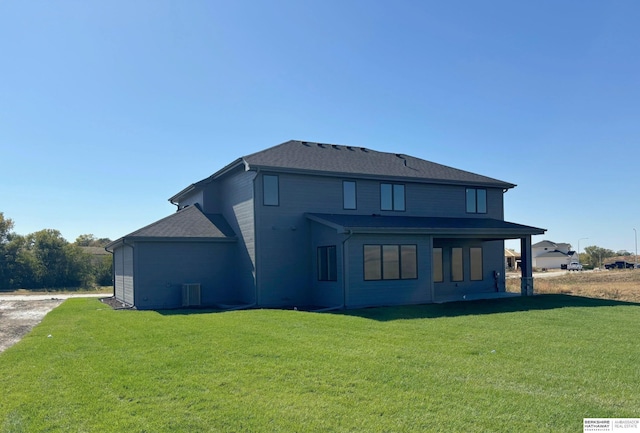 rear view of property featuring a lawn