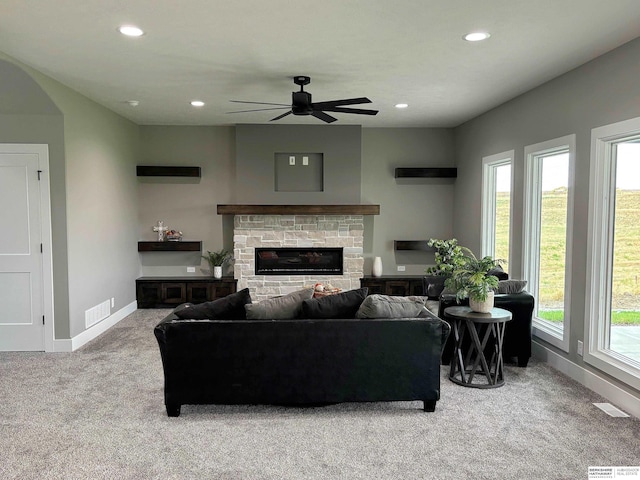 living room with ceiling fan, carpet floors, and a fireplace