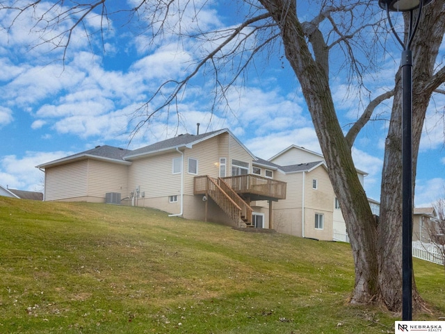 rear view of property featuring a lawn, central air condition unit, and a deck