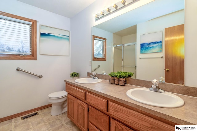 bathroom with vanity, toilet, and a shower with door