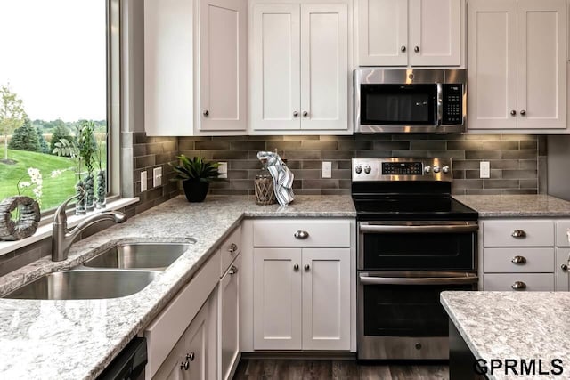 kitchen featuring tasteful backsplash, white cabinetry, sink, and stainless steel appliances