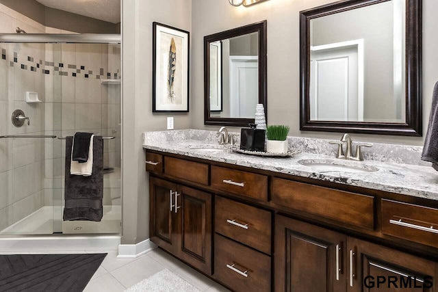 bathroom featuring tile patterned flooring, an enclosed shower, and vanity