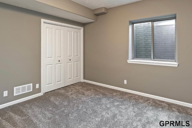 unfurnished bedroom with a closet and carpet