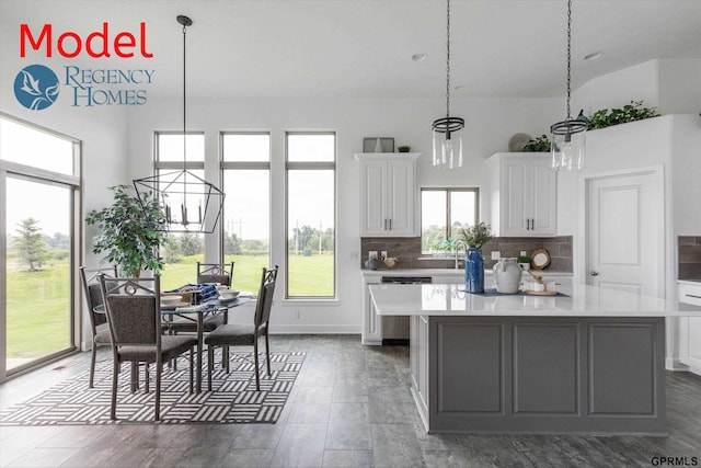 kitchen featuring a kitchen island, hanging light fixtures, white cabinetry, and tasteful backsplash