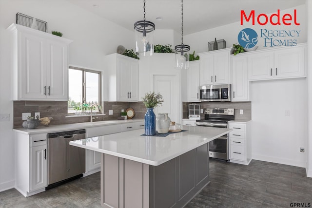 kitchen featuring appliances with stainless steel finishes, a center island, white cabinets, and decorative light fixtures