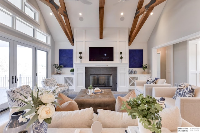 living room featuring beam ceiling, a towering ceiling, and french doors