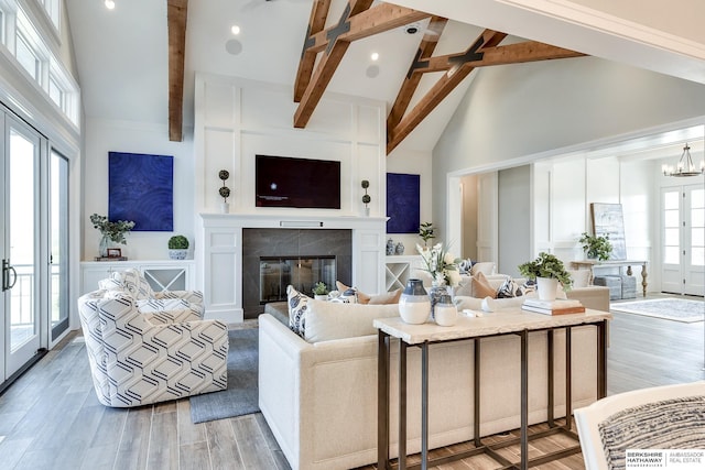 living room with high vaulted ceiling, light hardwood / wood-style flooring, and a healthy amount of sunlight