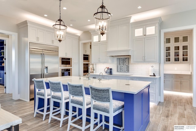 kitchen featuring white cabinetry, sink, an island with sink, and stainless steel appliances