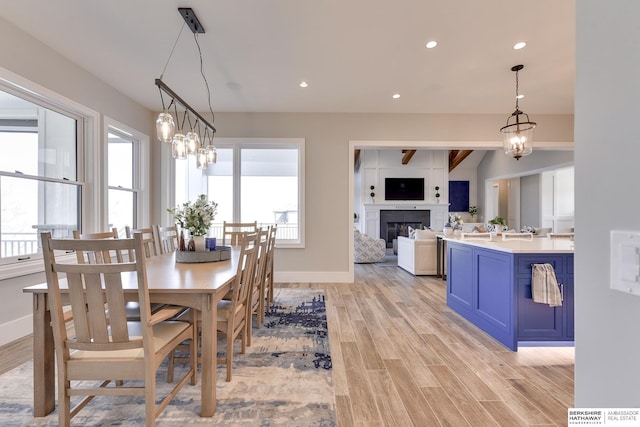 dining space with light hardwood / wood-style floors, plenty of natural light, and a notable chandelier