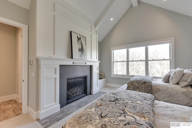 living room featuring a tile fireplace, light wood-type flooring, and vaulted ceiling with beams