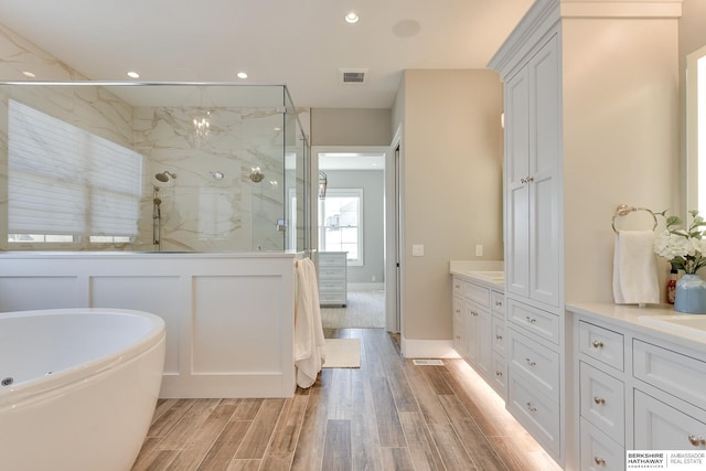 bathroom featuring vanity and independent shower and bath