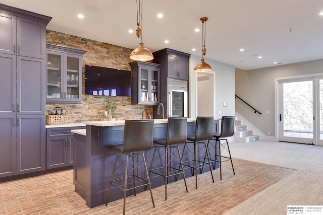 bar featuring tasteful backsplash, wine cooler, decorative light fixtures, gray cabinets, and light carpet