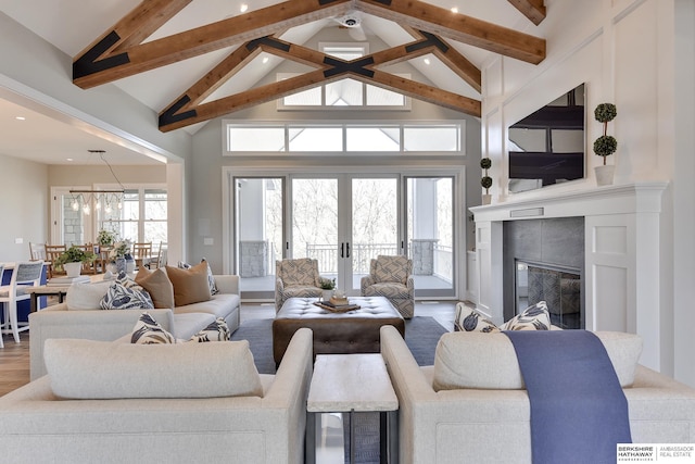 living room with high vaulted ceiling, a tile fireplace, french doors, beam ceiling, and wood-type flooring