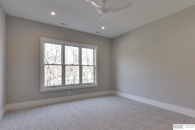 spare room featuring light carpet and ceiling fan