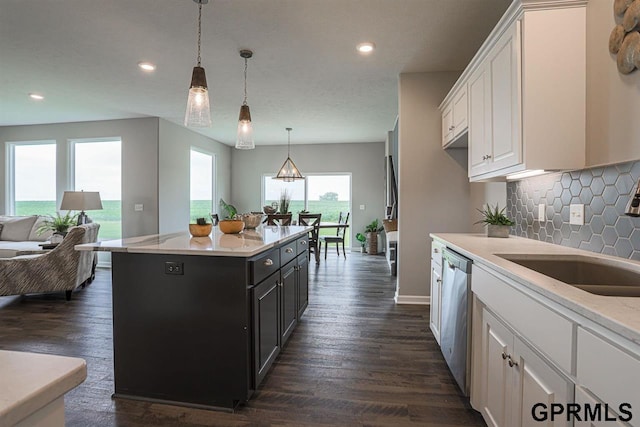 kitchen with dishwasher, a center island, pendant lighting, sink, and white cabinetry