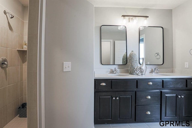 bathroom featuring vanity, tile patterned flooring, and tiled shower