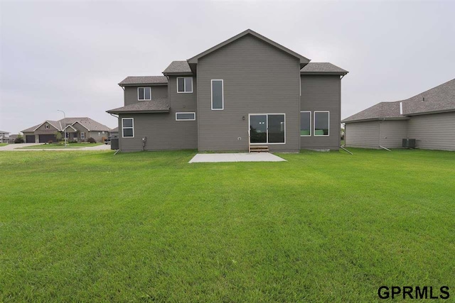 back of property with a patio area, a yard, and central AC