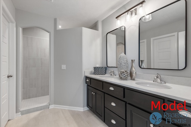 bathroom with tiled shower and vanity