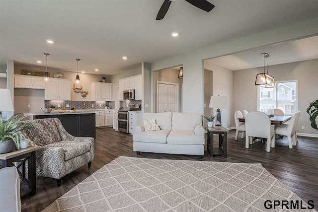 living room with ceiling fan and dark hardwood / wood-style floors