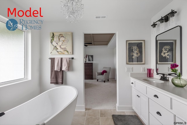 bathroom with tile patterned flooring, vanity, a washtub, and a chandelier