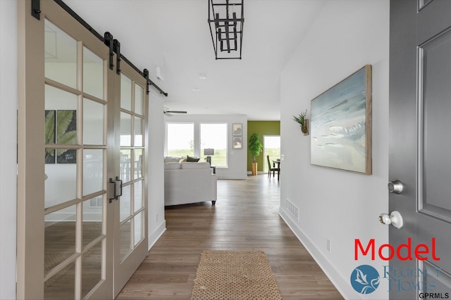 corridor with wood-type flooring and french doors