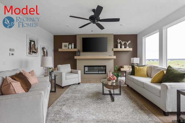 living room featuring a large fireplace, ceiling fan, and hardwood / wood-style floors