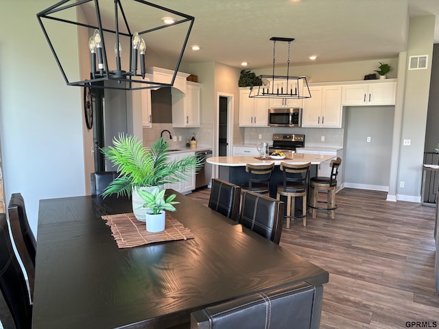 dining space with baseboards, visible vents, dark wood-type flooring, and recessed lighting