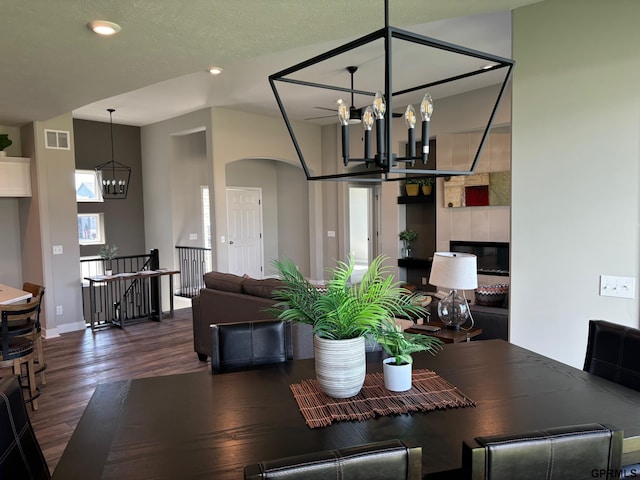 dining room featuring baseboards, visible vents, arched walkways, wood finished floors, and a chandelier