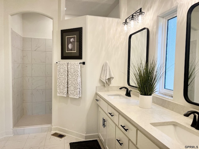 bathroom with marble finish floor, a sink, visible vents, and baseboards