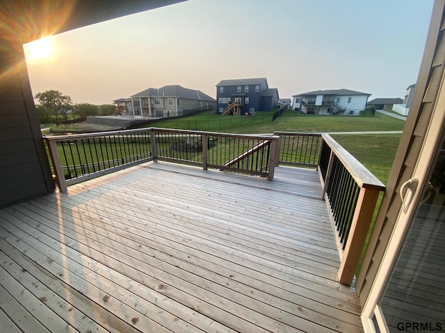 deck at dusk featuring a lawn