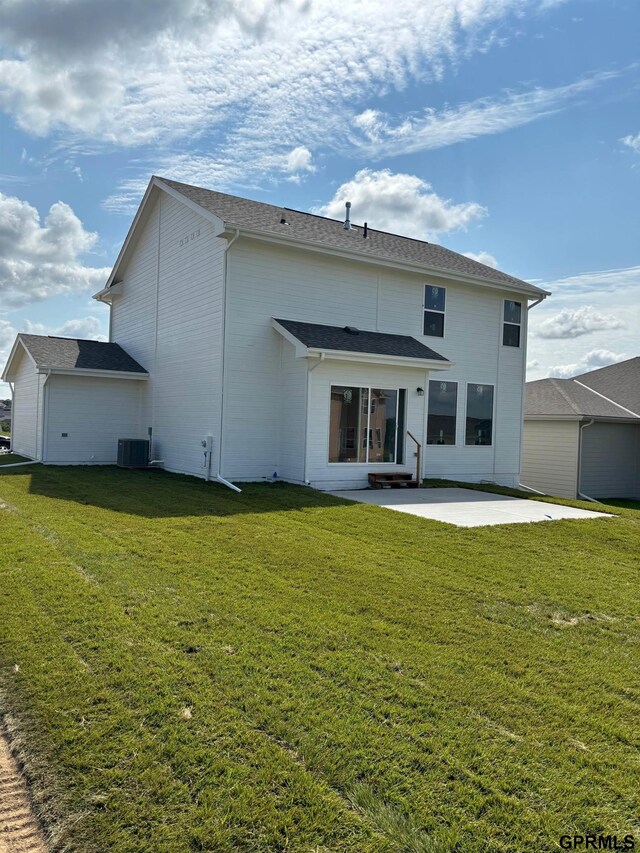 rear view of property featuring a lawn and a patio area