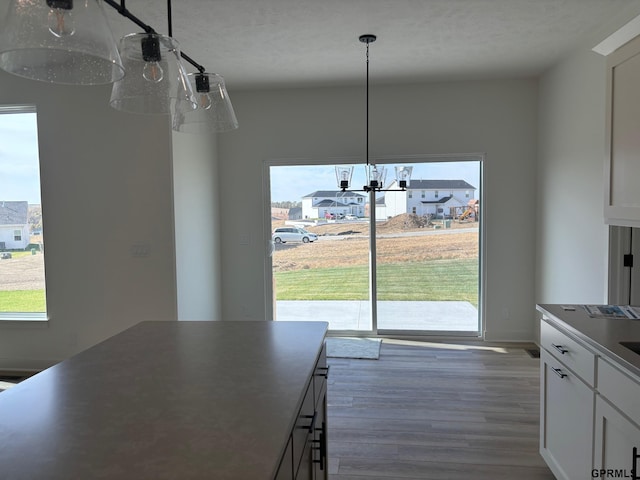 unfurnished dining area with a notable chandelier and dark hardwood / wood-style flooring