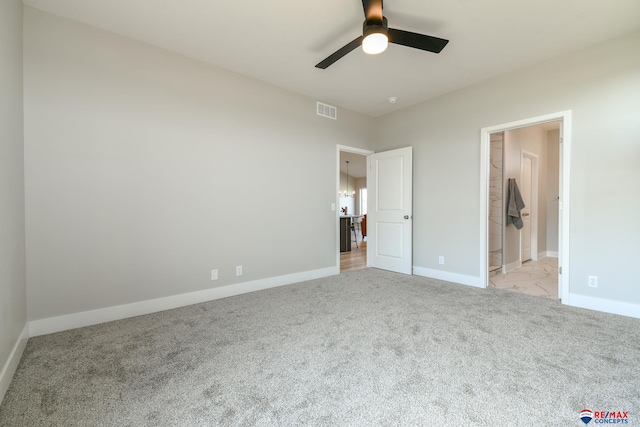 unfurnished bedroom featuring a walk in closet, ceiling fan, a closet, and light carpet