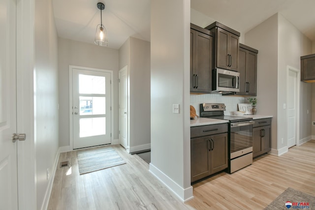 kitchen with pendant lighting, light wood-type flooring, tasteful backsplash, dark brown cabinetry, and stainless steel appliances