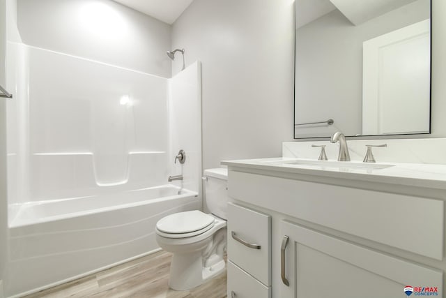 full bathroom featuring hardwood / wood-style flooring, vanity,  shower combination, and toilet