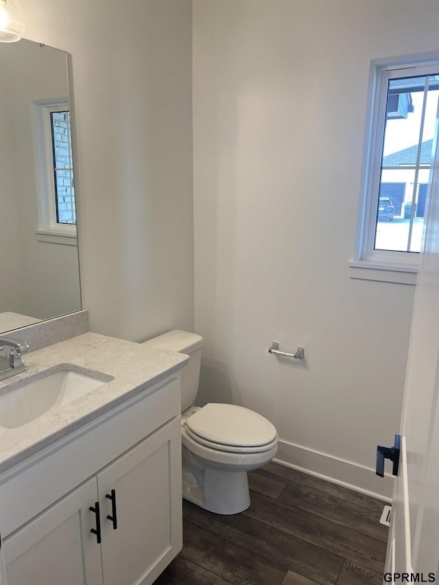 bathroom featuring hardwood / wood-style flooring, vanity, and toilet