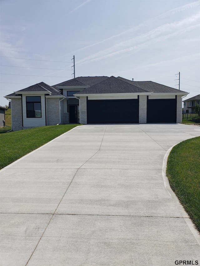 view of front of house featuring a garage and a front lawn