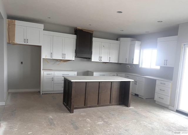 kitchen with custom exhaust hood, a kitchen island, and white cabinetry