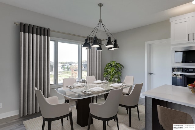 dining area with a notable chandelier and light hardwood / wood-style floors