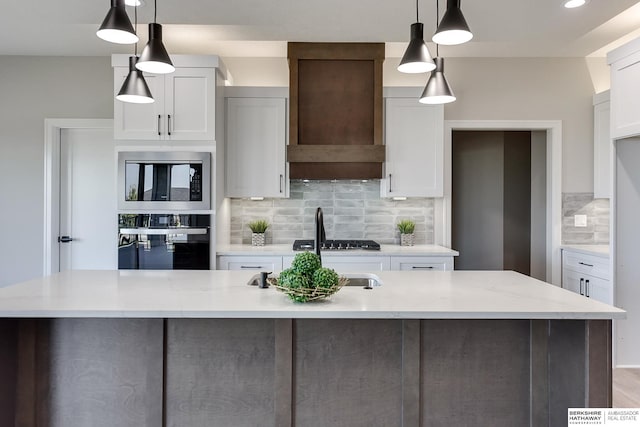 kitchen featuring white cabinets, decorative light fixtures, oven, and light stone counters