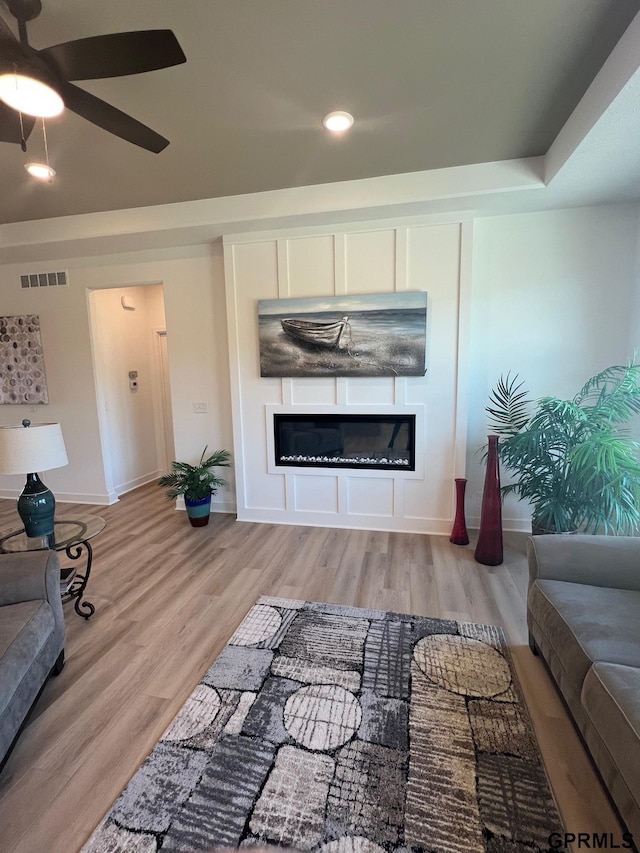 living room featuring ceiling fan and light hardwood / wood-style floors