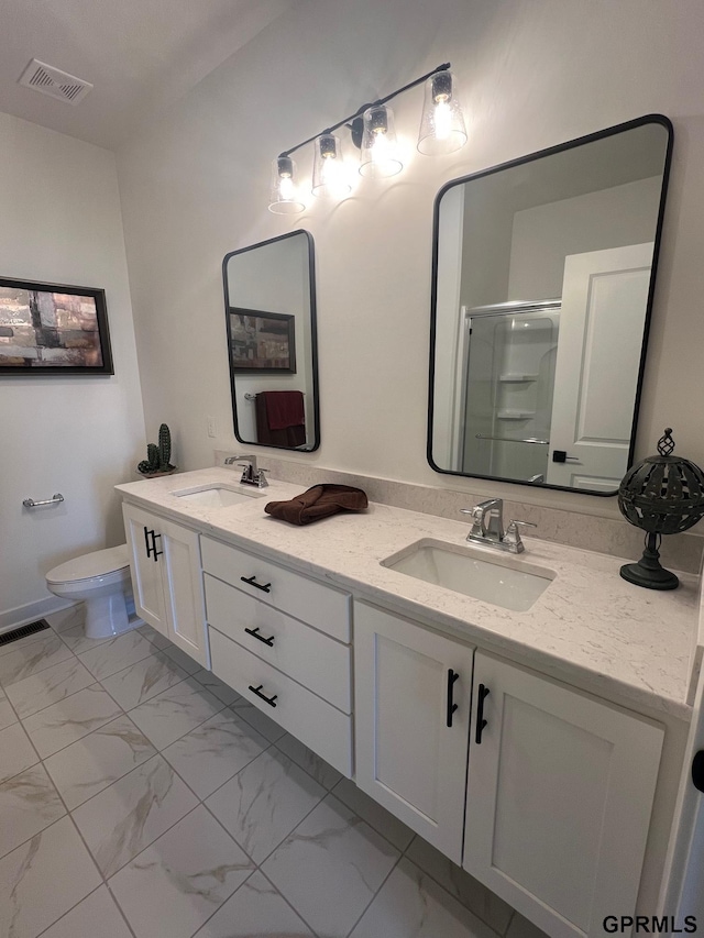 bathroom featuring toilet, vanity, and a shower with shower door