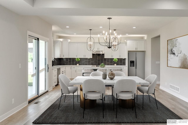 dining space featuring light hardwood / wood-style flooring and a chandelier