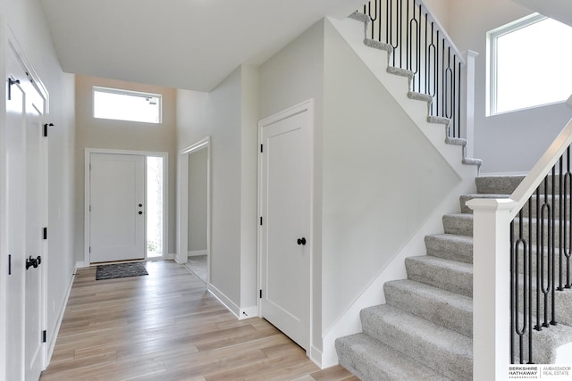 entryway with a high ceiling and light hardwood / wood-style flooring