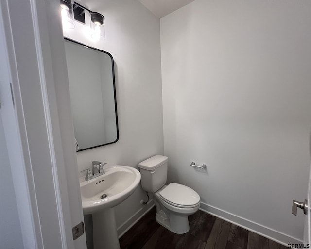 bathroom featuring hardwood / wood-style flooring, toilet, and sink