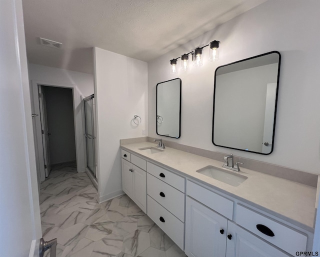 bathroom featuring vanity, a textured ceiling, and walk in shower